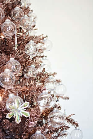 A Beautiful, Snow-covered Aesthetic Christmas Tree Standing Tall In A Winter Landscape Wallpaper