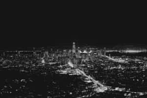 A Black And White Photo Of A City At Night Wallpaper