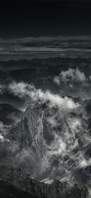 A Black And White Photo Of Clouds Over A Mountain Wallpaper