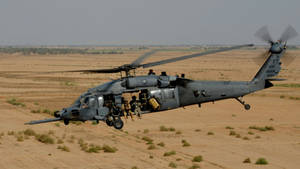 A Black Hawk Helicopter Hovering In The Sky Wallpaper