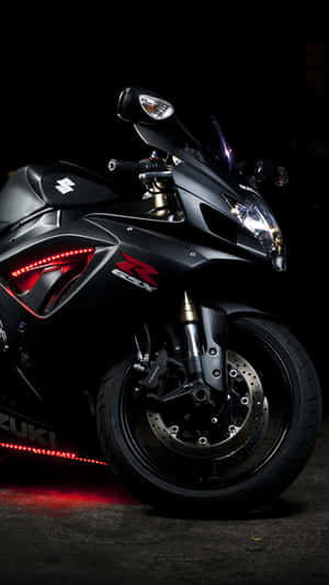 A Black Motorcycle Is Parked In A Dark Area Wallpaper