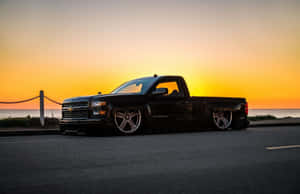 A Black Pickup Truck Parked On The Side Of The Road Wallpaper