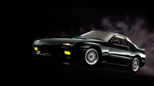 A Black Sports Car Is Shown In A Dark Background Wallpaper