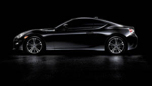 A Black Sports Car Is Shown In A Dark Room Wallpaper