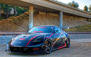 A Black Sports Car Parked Under A Bridge Wallpaper