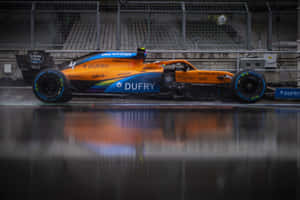 A Blue And Orange Racing Car Is Sitting On The Track Wallpaper