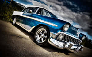 A Blue And White Classic Car Parked In The Parking Lot Wallpaper