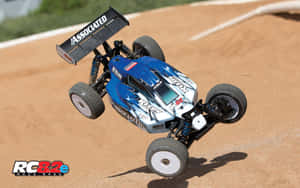 A Blue And White Rc Buggy Is Flying Through The Air Wallpaper