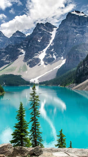 A Blue Lake Surrounded By Mountains And Trees Wallpaper