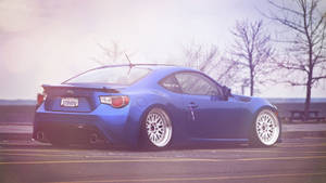 A Blue Sports Car Parked In A Parking Lot Wallpaper