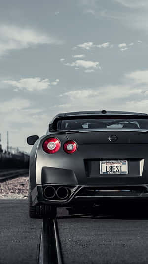 A Bright Red Nissan Gtr Sports Car Showcased Against A Blue Background. Wallpaper