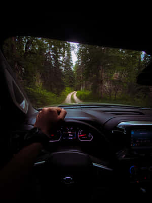 A Car Driving Down A Road Wallpaper