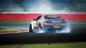 A Car Is Drifting On A Track With Smoke Coming Out Of It Wallpaper