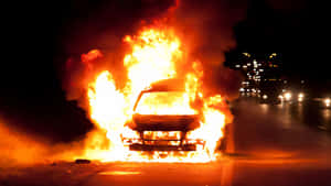 A Car Is On Fire On The Side Of The Road Wallpaper