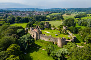 A Castle In The Middle Of A Green Field Wallpaper