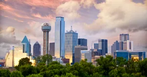 A City Skyline With Trees And Clouds Wallpaper