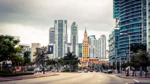 A City Street With Tall Buildings And Trees Wallpaper