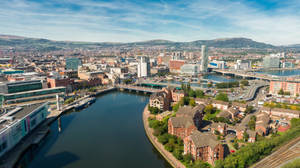 A City With A River And Buildings In The Background Wallpaper