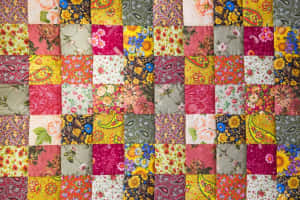 A Colorful Quilt With A Floral Pattern Wallpaper