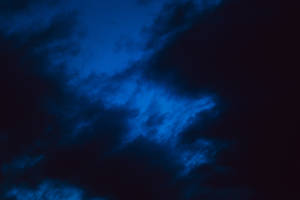 A Dark, Blue Sky Filled With Amazing, Dynamic Clouds Wallpaper
