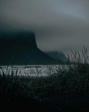 A Dark Sky With A Mountain In The Background Wallpaper