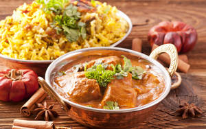 A Delectable Lunch With Butter Chicken And Biryani Rice Wallpaper