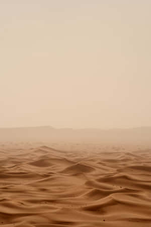 A Desert Landscape With Sand And Mountains Wallpaper