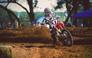 A Dirt Bike Rider Is Riding A Dirt Bike Wallpaper