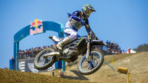 A Dirt Bike Rider Is Riding His Bike On A Dirt Track Wallpaper