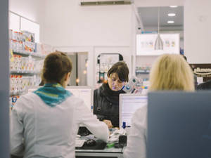 A Female Customer Purchasing From Pharmacist Wallpaper