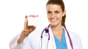 A Female Doctor Holding Up A Blank Card Wallpaper