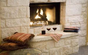 A Fireplace With A Book And Wine Wallpaper