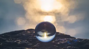 A Glass Ball Sitting On Top Of A Rock Wallpaper