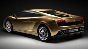 A Gold Lamborghini Parked At Sunset Wallpaper