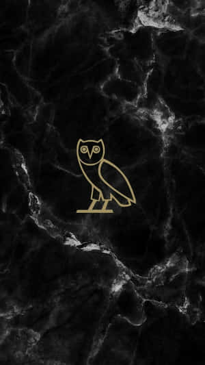 A Gold Owl Logo On A Black Marble Background Wallpaper