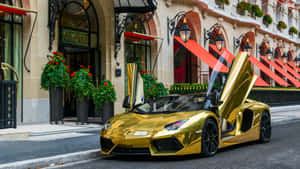 A Gold Sports Car Parked In Front Of A Hotel Wallpaper