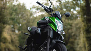 A Green And Black Motorcycle Parked On A Road Wallpaper