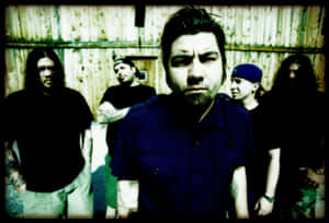 A Group Of Men Standing In Front Of A Wooden Building Wallpaper