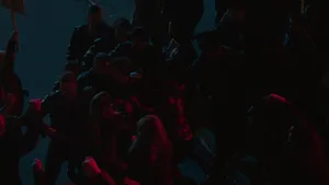 A Group Of People Are Standing In A Street At Night Wallpaper