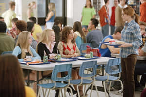 A Group Of People Sitting At Tables In A School Cafeteria Wallpaper