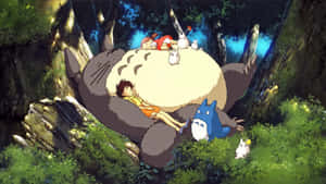 A Group Of People Sitting On Top Of A Giant Totoro Wallpaper