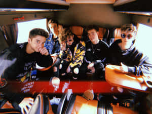 A Group Of Young Men Sitting In A Van Wallpaper