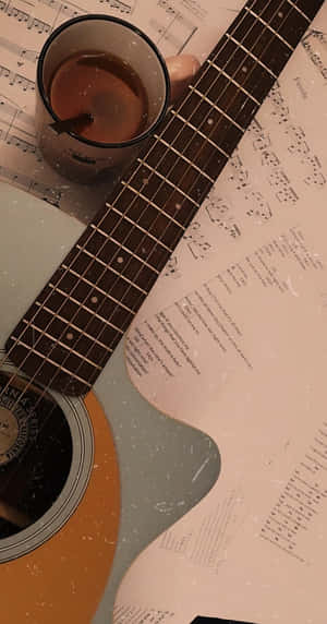 A Guitar And Cup Of Coffee On A Sheet Of Music Wallpaper