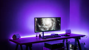 A High-end Gaming Setup In A Purple Themed Room Wallpaper