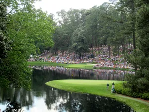 A Large Crowd Watching Golfers Play Wallpaper