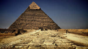 A Large Pyramid With People Walking Around It Wallpaper