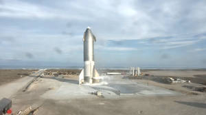 A Large Rocket Is Being Launched From A Field Wallpaper