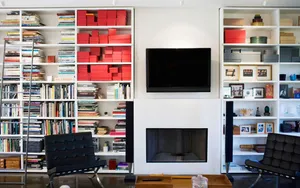 A Living Room With A Fireplace And Bookshelves Wallpaper