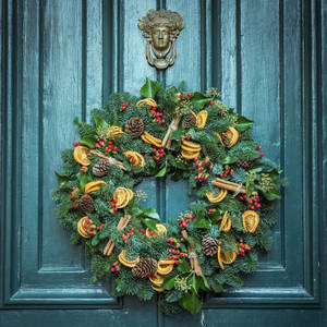 A Lovely Christmas Wreath Garnished With Zesty Orange Slices Wallpaper