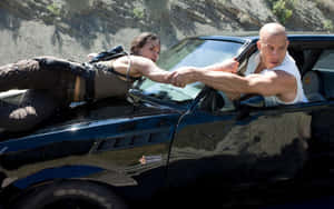 A Man And Woman Are Laying On The Side Of A Car Wallpaper